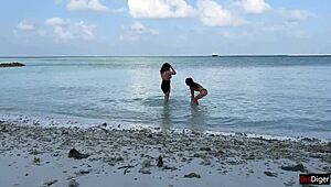 Matrigna e figliastra prosperose fanno docce dorate sulla spiaggia pubblica
