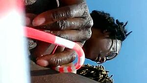 Look at this ebony slut fingering her pussy on the beach!