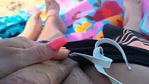 Le hago una paja en la playa pública hasta que se corre