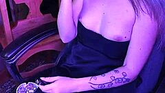 Mistress smokes a cigarette while commanding attention in her dark lair.