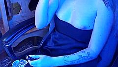 Mistress smokes a cigarette while commanding attention in her dark lair.