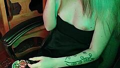 Mistress smokes a cigarette while commanding attention in her dark lair.