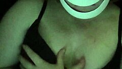 Petite girl gently caresses her natural big tits through black shirt and bra