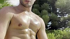 Bold oily masturbation in public outdoor setting.