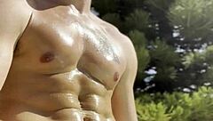 Bold oily masturbation in public outdoor setting.