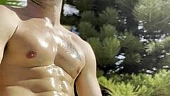 Bold oily masturbation in public outdoor setting.