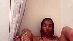 davina bathes in the shower, getting all wet and soapy.