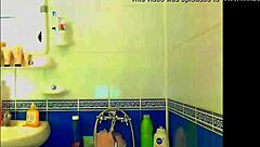 Tattooed model plays with glass dildo in bathroom