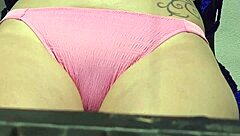 Smører solcreme på patter under offentlig solbadning, blond husmor viser lille 18+ krop på stranden