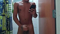 acordei com tesão e gozei durante o banho, sentindo o pau grande pulsar forte no chuveiro.