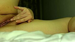 In this scene, tight pussy gets wet from multiple orgasms during solo fingering in bed.