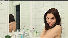 brunette steps under the warm shower, fingers her shaved wet pussy till she cums