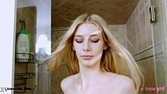 blonde muse steps under shower in casting glow
