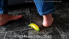 barefoot femdom tramples with banana toy underfoot