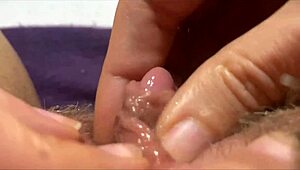 W zbliżeniu ona pociera ogromną owłosioną łechtaczkę i trzepie ją do tryskającego orgazmu.