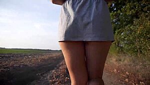 Går udendørs og blinker bar røv under kort nederdel med thong-trusser