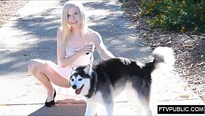 Girl walks dog in public park, flashing skirt outdoors.