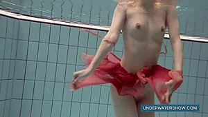 Katya Okuneva pozează ca fată de piscină în rochie roșie. Bruneta rusă se bucură de scenă de bikini pe plajă în aer liber.