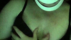 Petite girl gently caresses her natural big tits through black shirt and bra