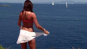 chick in bikini strips outdoors by cliff