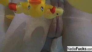 Sexy Nadia bathes with rubber duckies in solo relaxation