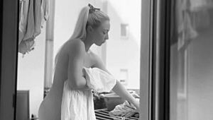 Голая пухлая женщина вешает бельё на балконе, чтобы соседи смотрели