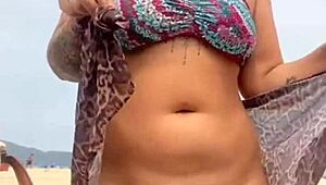 Young African woman strips naked on beach, guy gets hard, she grabs his erect penis