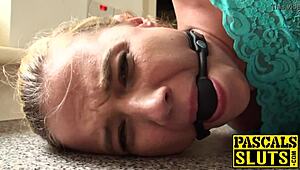 Bound blonde bitch gags on cock during rough BDSM domination with choking and spanking.