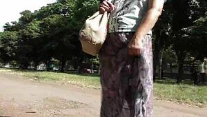 Femeie matură păroasă plimbă în rochie transparentă, face flashuri cu trupul în public