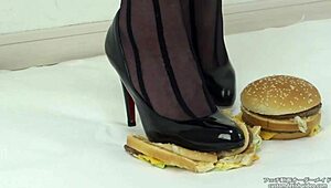 Japanese woman in stockings and heels crushes a hamburger under her feet in fetish food play