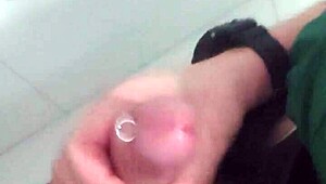 In the mall bathroom, the security guard casually takes a break to masturbate solo.
