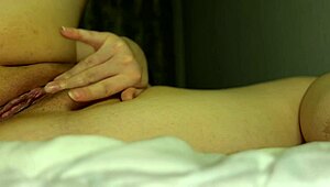 In this scene, tight pussy gets wet from multiple orgasms during solo fingering in bed.