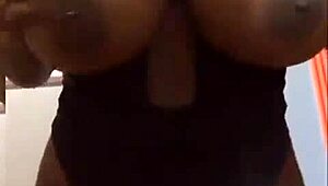 An ebony woman reveals her voluptuous figure and ample bosom in a captivating tale of allure and curves
