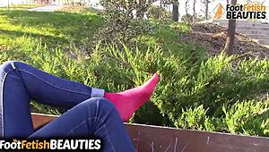 Brunette babe slips off socks to walk barefoot through the park