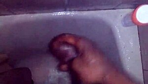 guy strokes his big black monster cock while showering and bathing until cum explodes