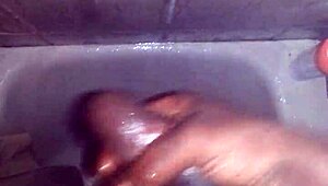 guy strokes his big black monster cock while showering and bathing until cum explodes