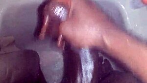 guy strokes his big black monster cock while showering and bathing until cum explodes