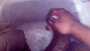 guy strokes his big black monster cock while showering and bathing until cum explodes