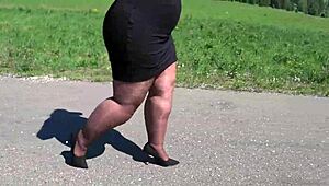 Зряла BBW дефилира в найлонови чорапи и токчета по пътя